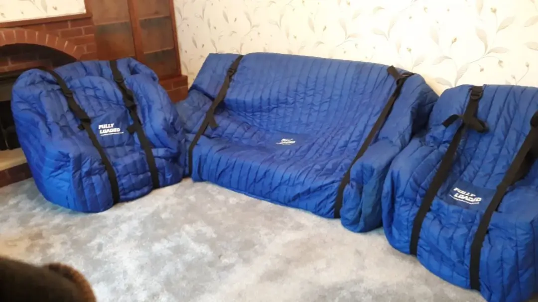 Sofa and chairs wrapped in protective covers for a house move